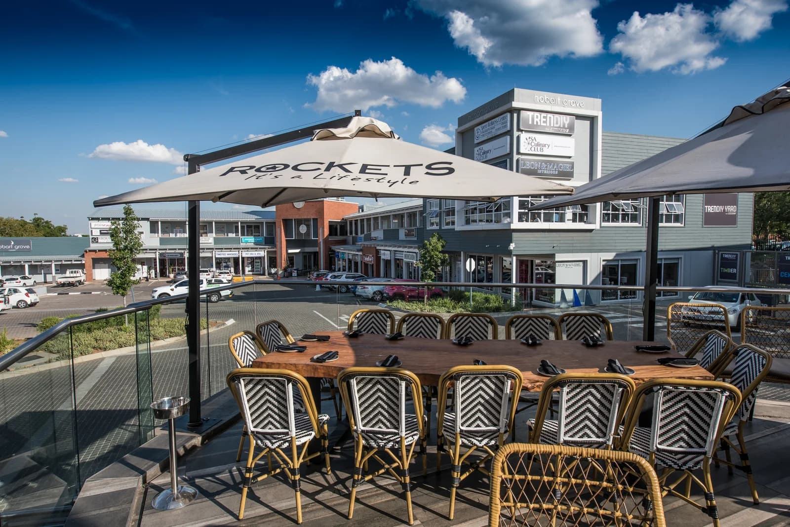 Logo-branded cantilever umbrella at an outdoor restaurant